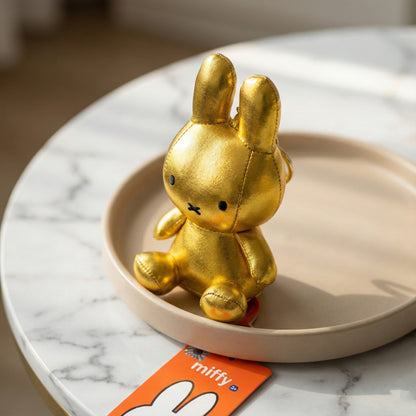 Close-up of gold metallic Miffy plush keychain showing shiny coating and details