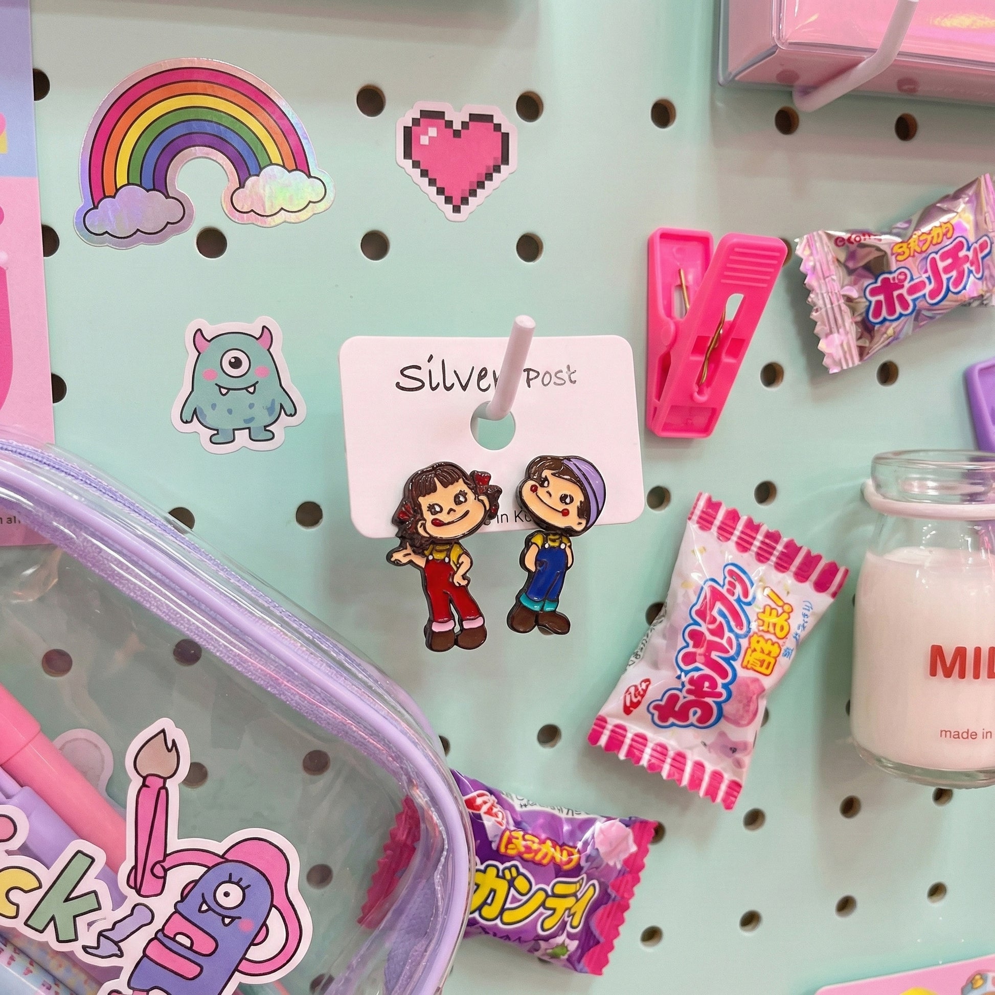 Kawaii flat lay Peko Poko earrings with rainbow stickers and Japanese candy
