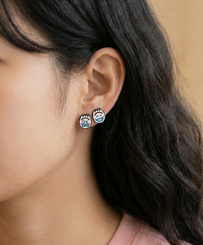 Close-up of woman wearing mismatched Forky character earrings showing shocked and happy expressions on earlobe