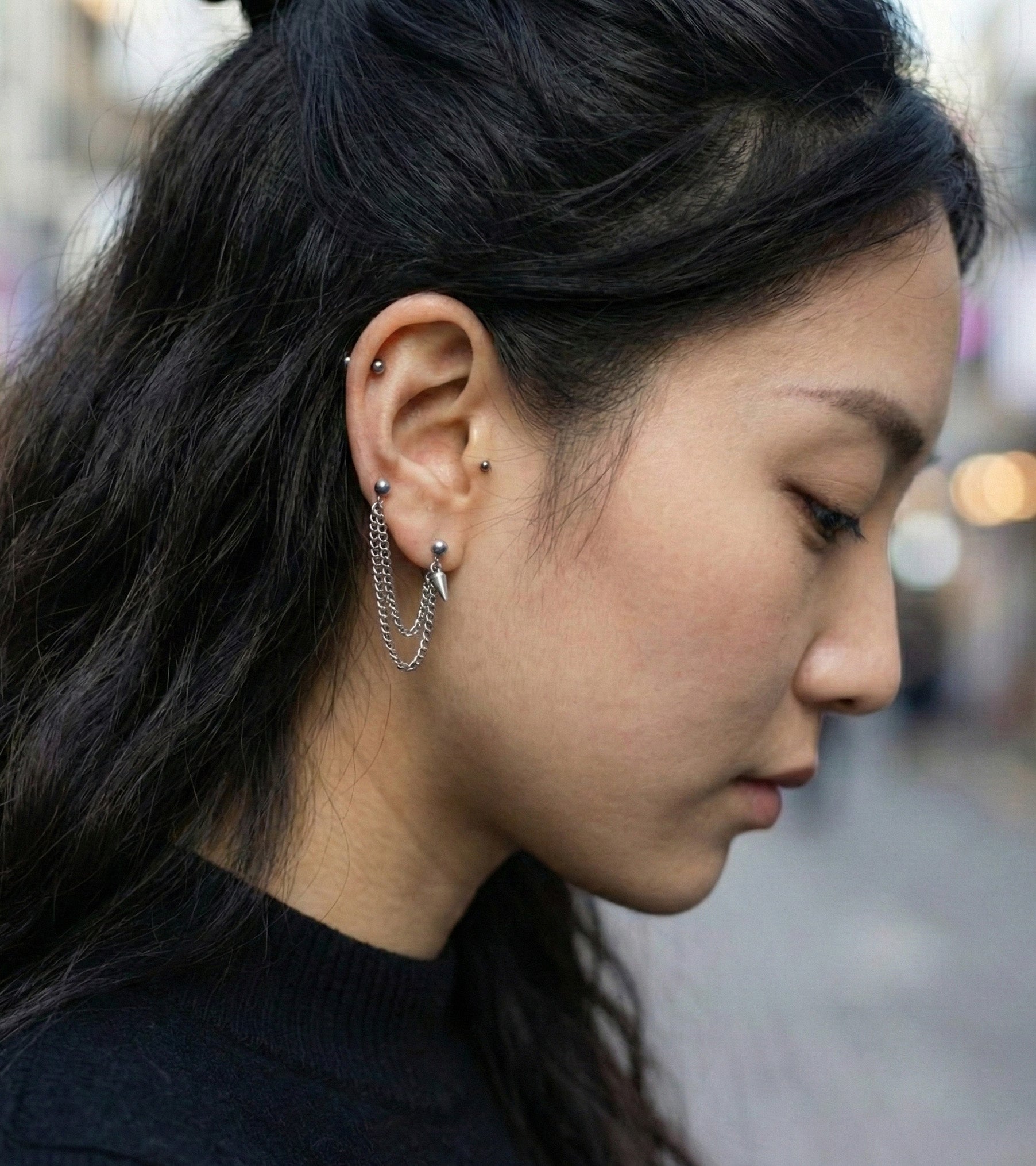  Profile shot showing diagonal chain piercing connecting lobe to cartilage  