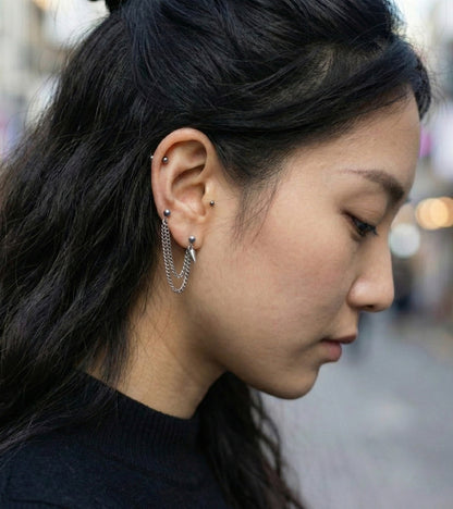  Profile shot showing diagonal chain piercing connecting lobe to cartilage  