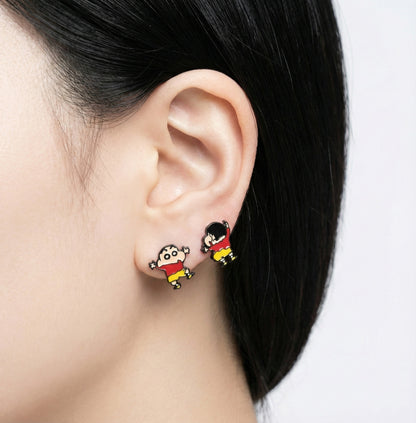 Crayon Shin-chan inspired child figure stud earrings in red and yellow worn on the earlobe.