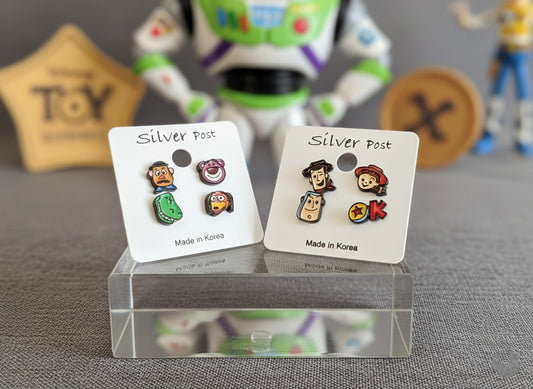 Two types of Toy Story earring sets displayed with Buzz Lightyear toy background