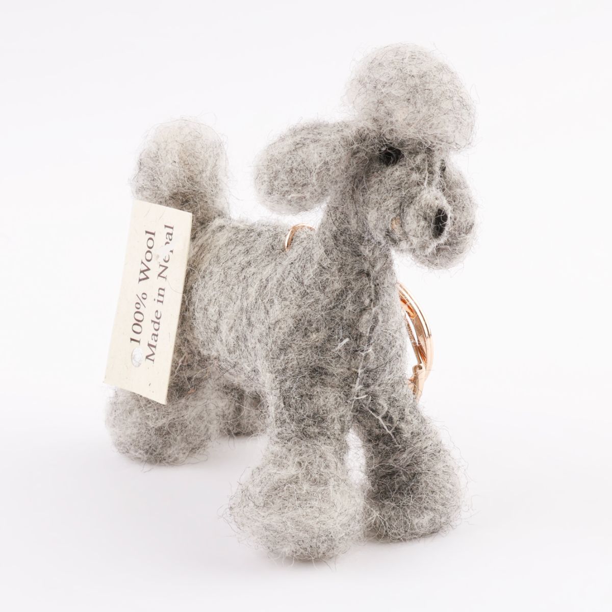Grey felted poodle keychain detail shot showing 100% Wool Made in Nepal certification tag