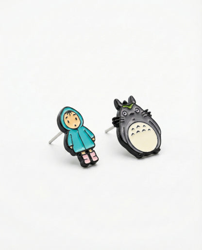 Detailed close-up of hand-painted Totoro and raincoat Mei brass stud earrings with silver posts