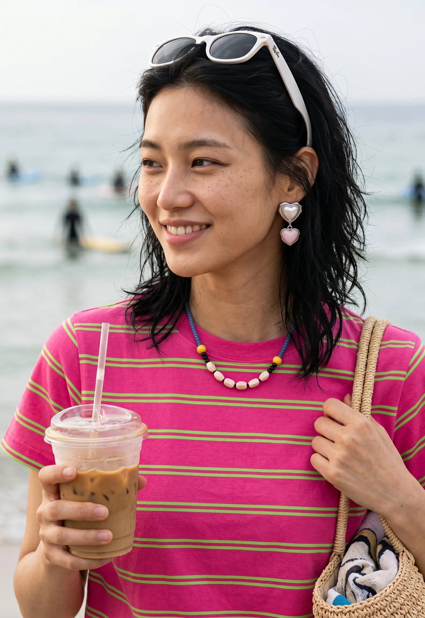Pink heart drop earrings styled with colorful beaded necklace, K-style jewelry for beach day look.