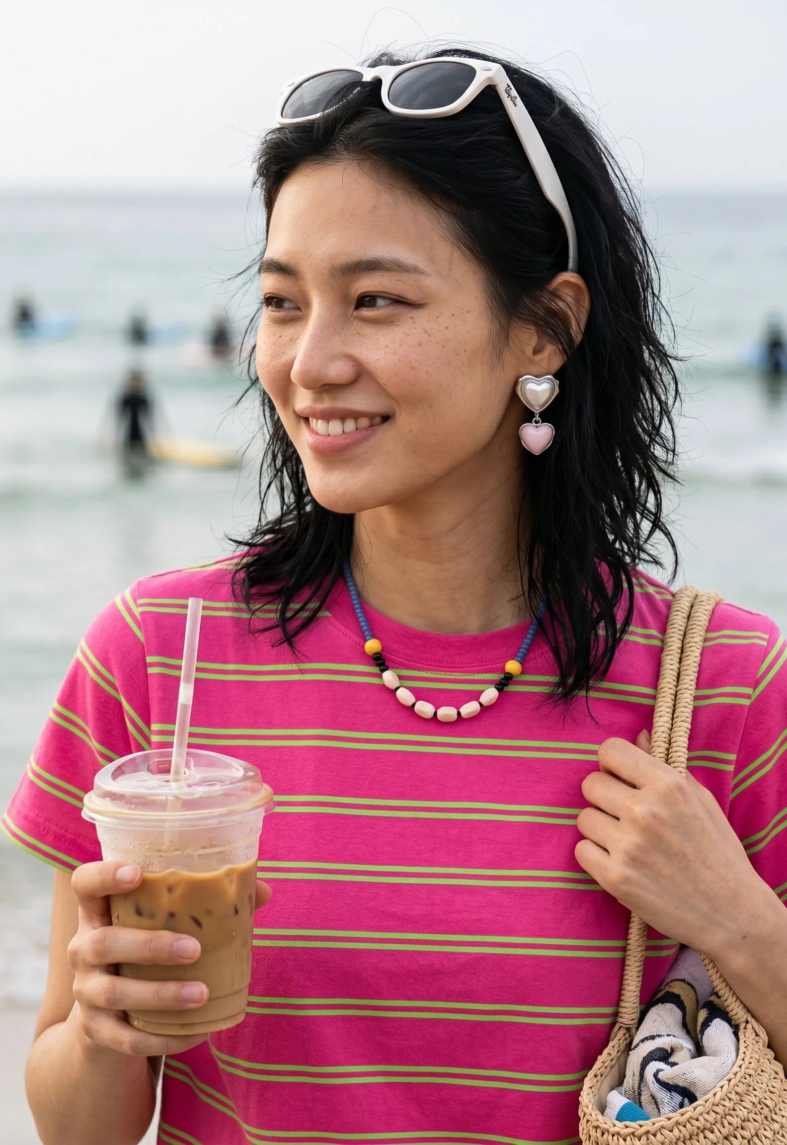 Pink heart drop earrings styled with colorful beaded necklace, K-style jewelry for beach day look.