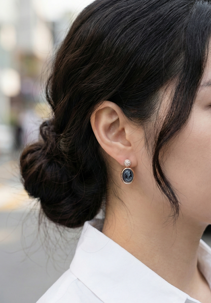 Outdoor shot of woman wearing pink cameo earring with bokeh background