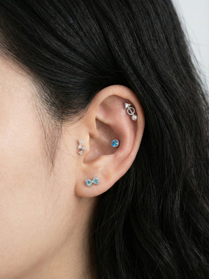 Detailed ear curation featuring vintage arrow CZ helix barbell with pearl dangle and blue gem accents