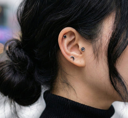 Outdoor portrait of woman with multiple cartilage piercings in black and silver