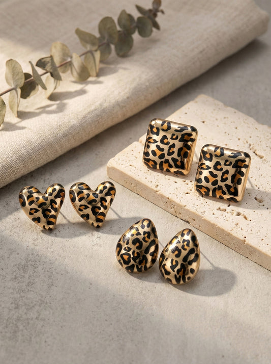  Flat lay of three leopard earring styles heart square teardrop with eucalyptus