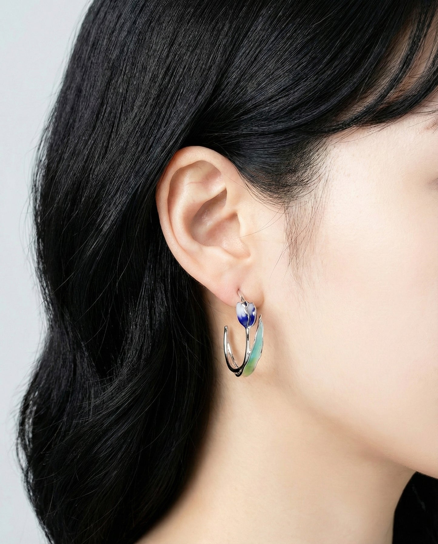 Profile shot of blue tulip hoop earring with titanium post