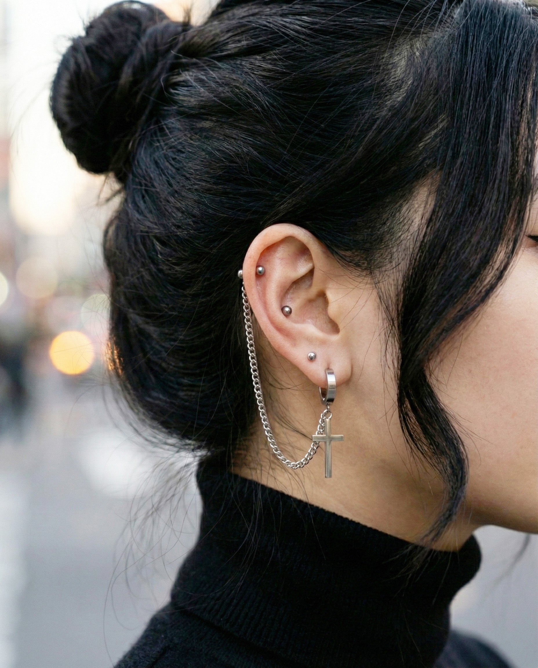 Profile shot showing industrial chain piercing connecting two piercings  