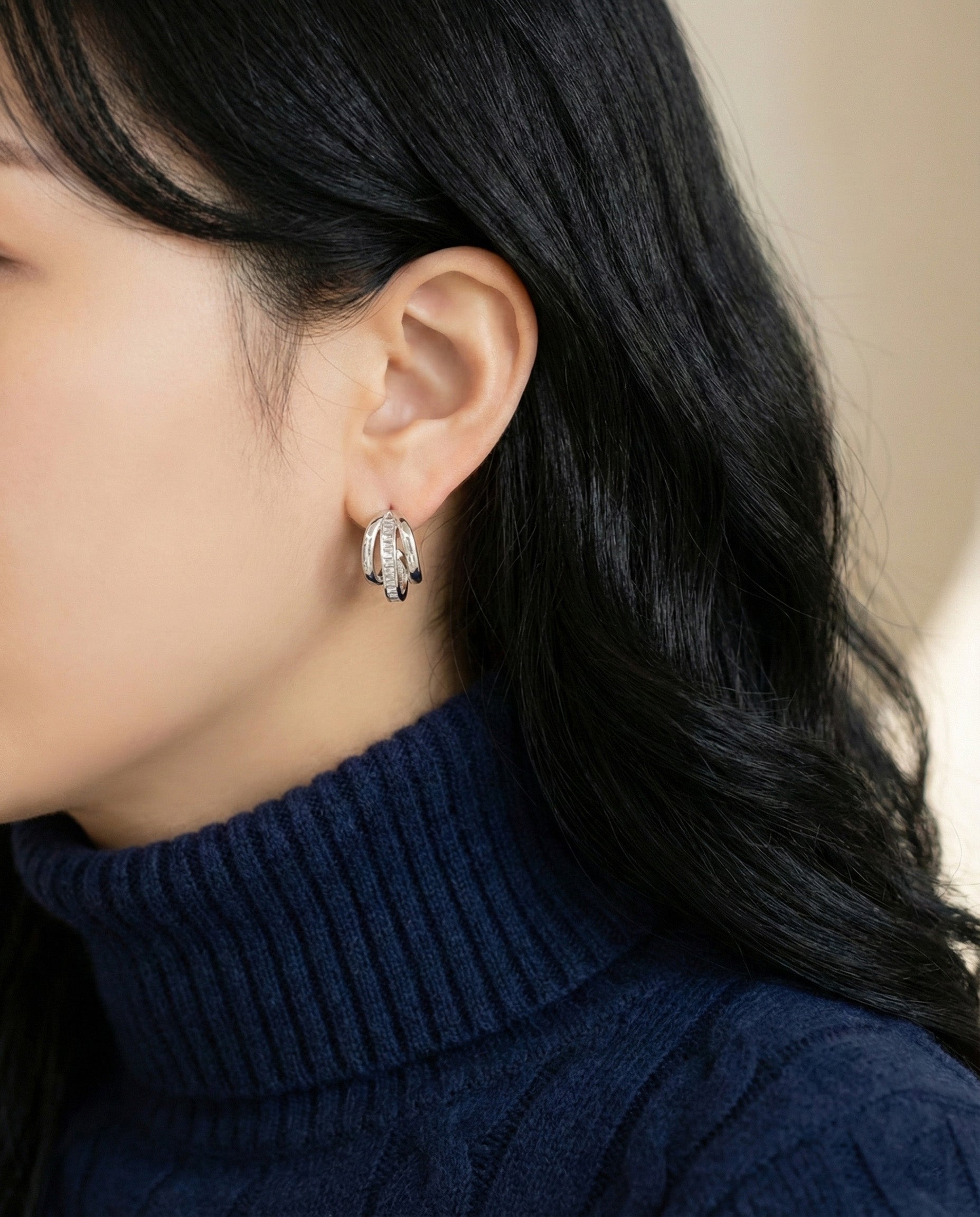 Profile view showing triple band layered huggie hoops with baguette crystals