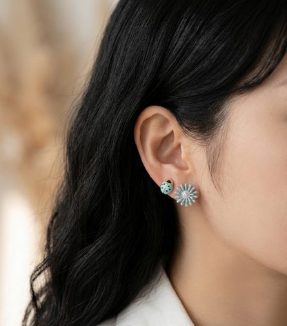 Close-up of a model wearing the Fresh Mint set, featuring a mint green daisy and a matching mint ladybug stud earring.