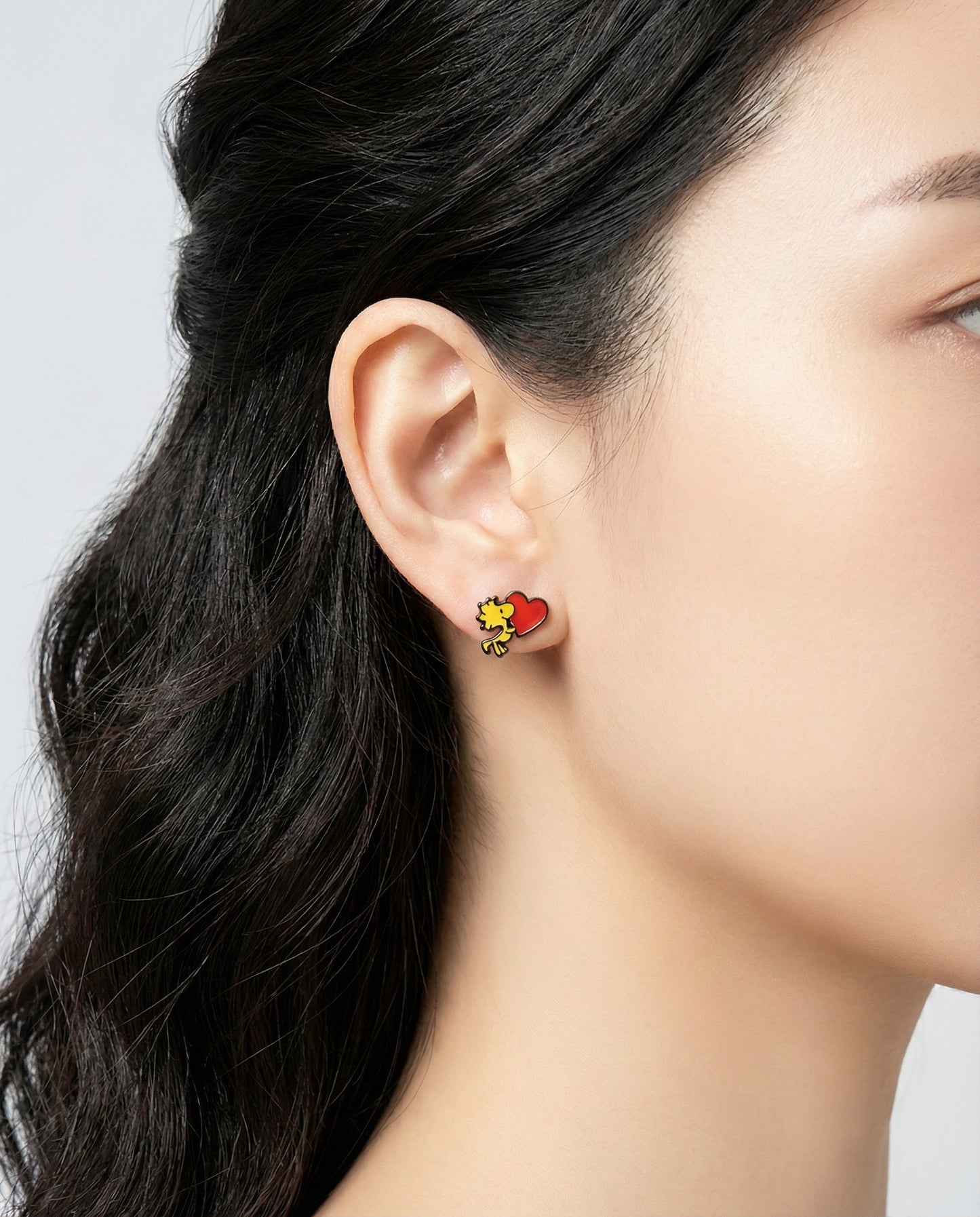 Close-up view of Woodstock heart earring on ear