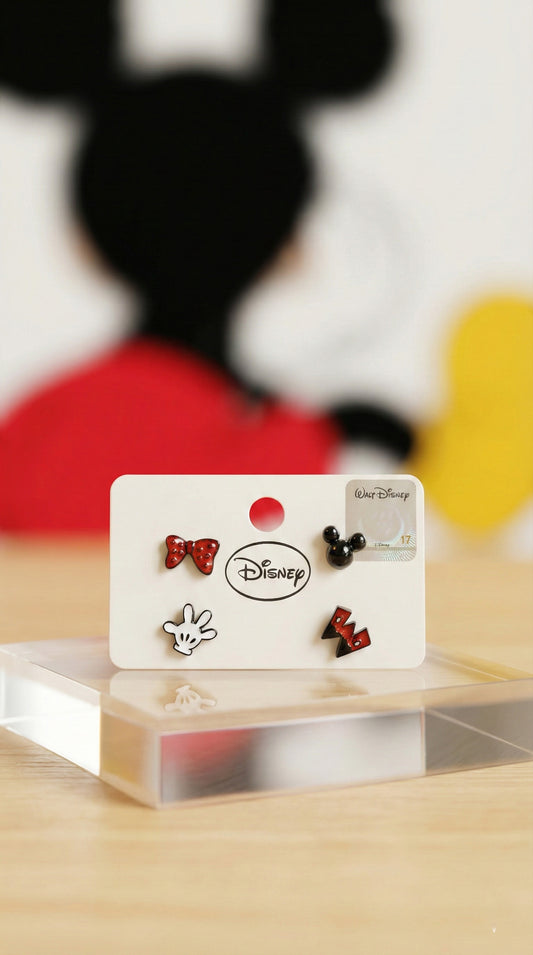 Disney official licensed Mickey Mouse 4-piece earring set on white card showing Minnie bow, Mickey head, glove, and pants designs