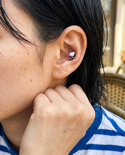 Curated ear styling featuring a minimal yet bold magenta Hello Kitty balletcore cartilage stud on a model with a casual striped tee.
