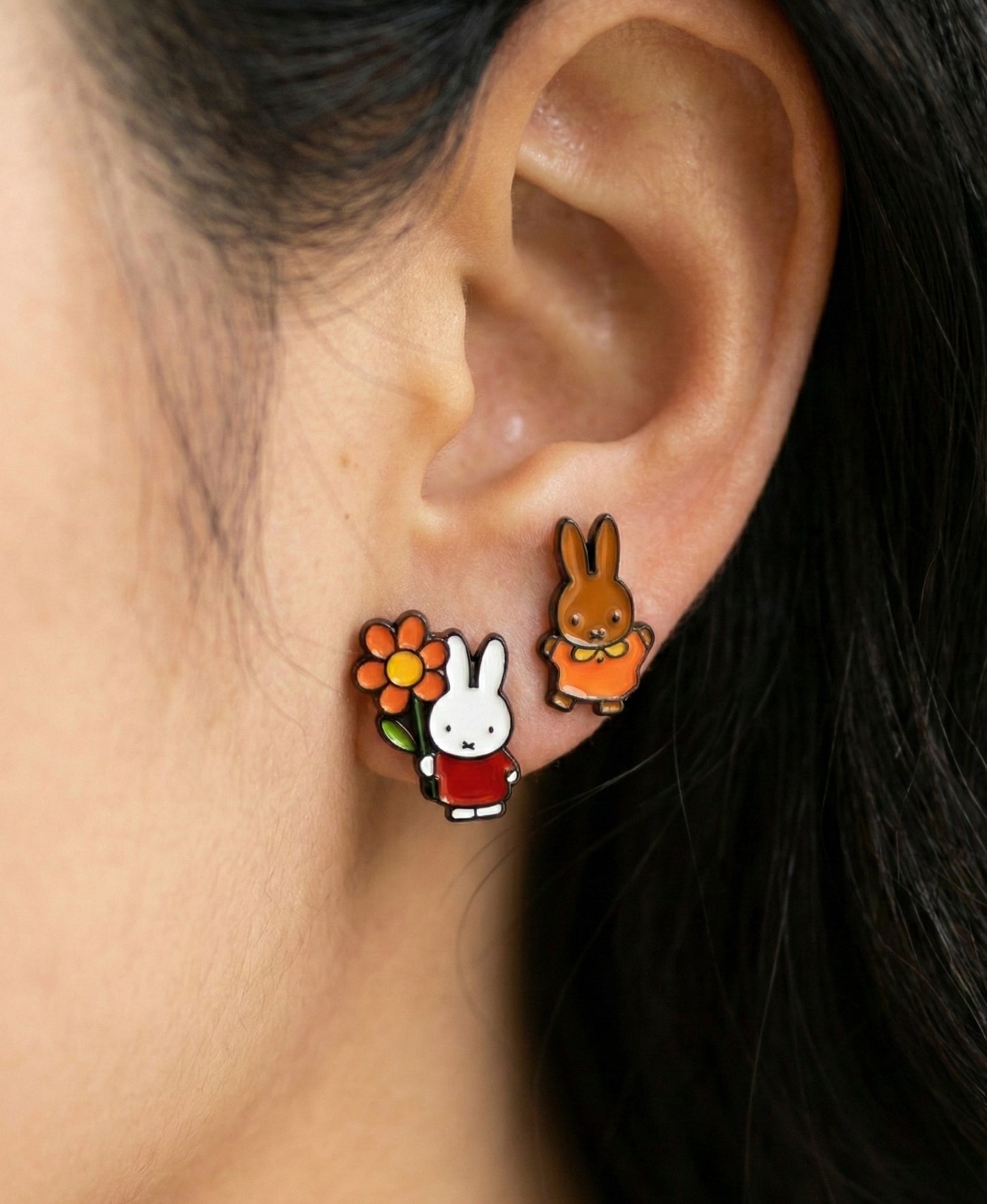 Miffy holding orange flower and Melanie brown bunny earrings worn together, hypoallergenic 925 silver posts for sensitive ears