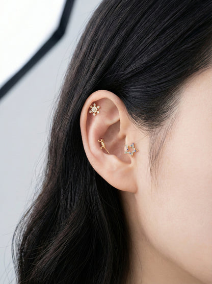 Multiple gecko piercings worn on helix and inner conch with star stud, curated ear styling