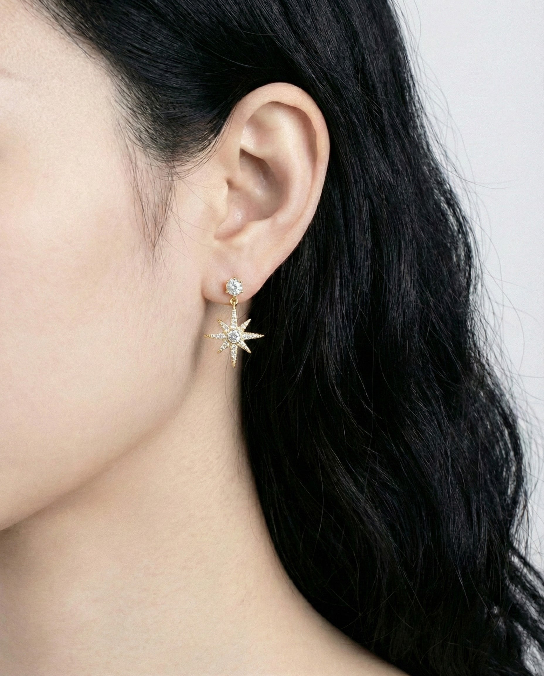 Close-up of gold plated moon and star earrings