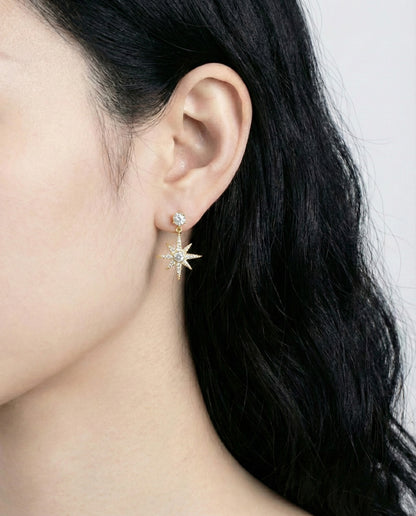 Close-up of gold plated moon and star earrings