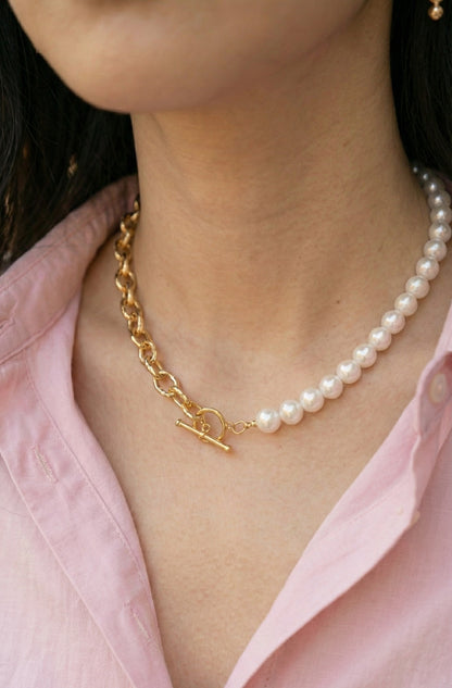 Close-up of woman wearing half pearl half chain toggle choker necklace with pink shirt