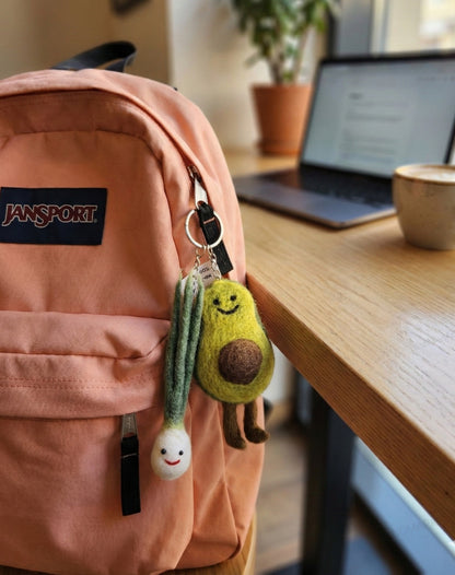 Pink JanSport backpack styled with avocado and scallion felt keychains