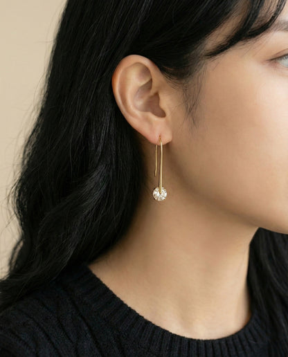 Model wearing gold plated long drop U-hook earrings with black knit sweater showing elegant neckline
