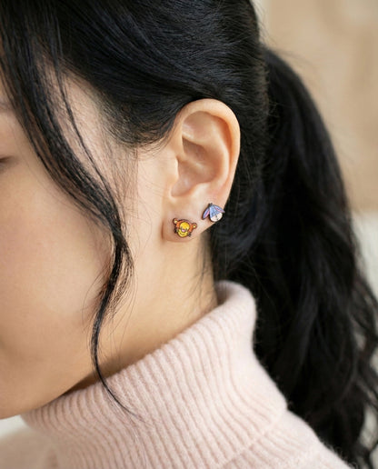 Tigger and Eeyore earrings layered on ear showcasing mix-and-match styling