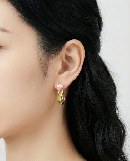 Woman wearing pink gradient tulip hoop earrings with gold base