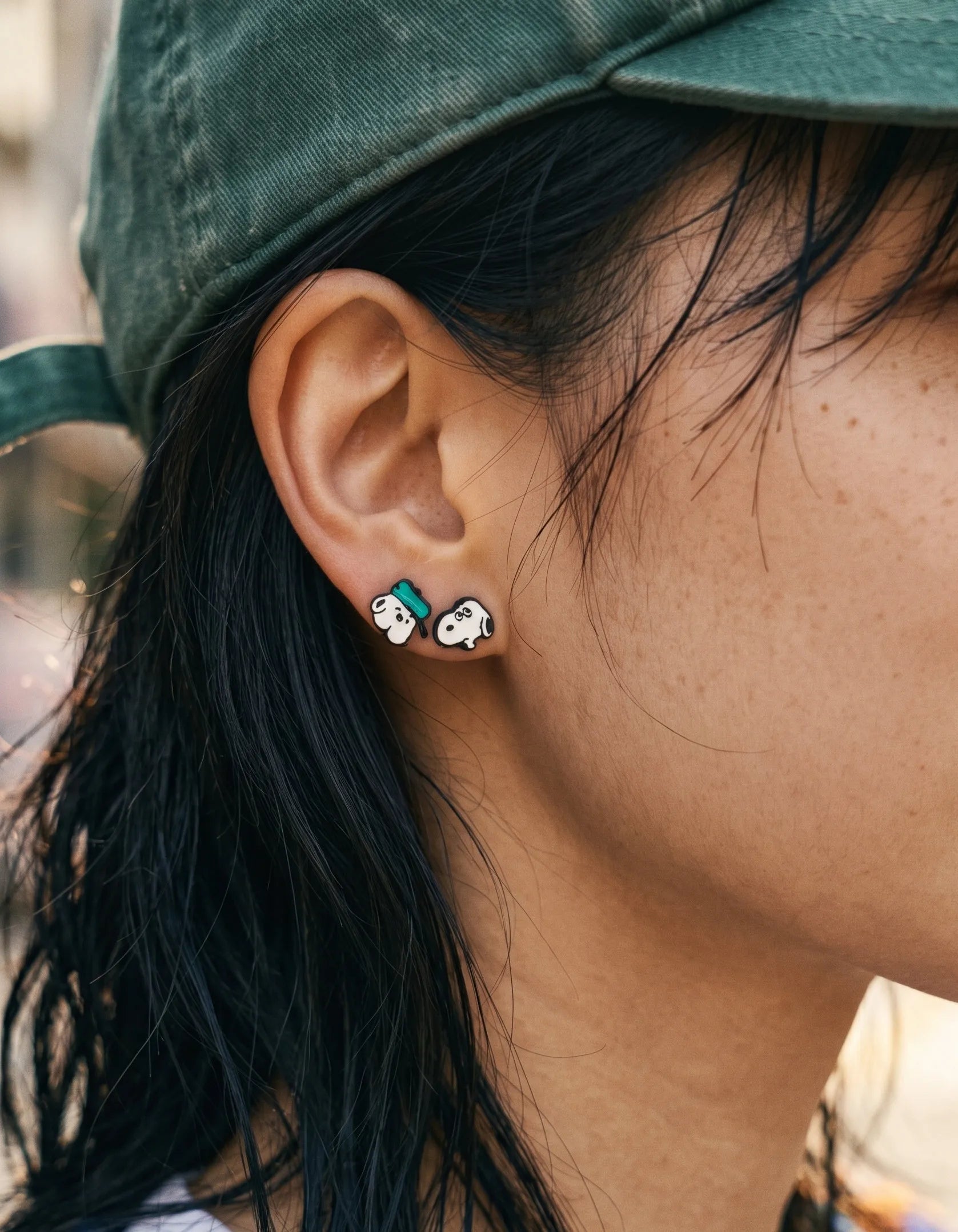 Curated ear piercing inspo with vintage cartoon studs, streetwear accessory look