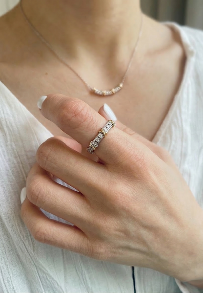 The 925 silver two-tone X-cross ring styled with a white linen blouse and a delicate necklace — showcasing everyday elegant styling