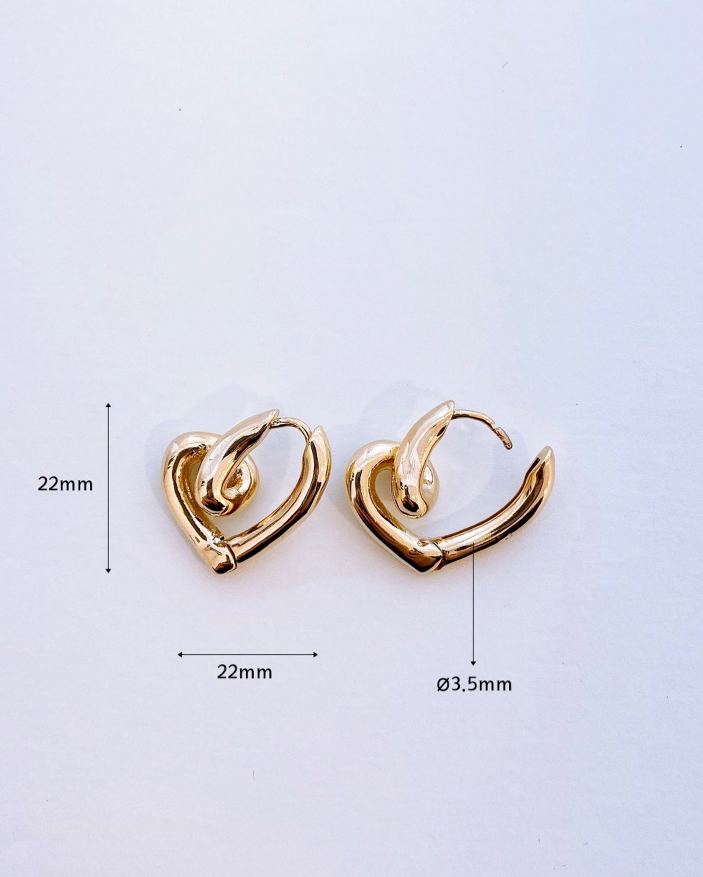 Gold heart knot earrings with size measurements 22mm x 22mm, 3.5mm thickness reference