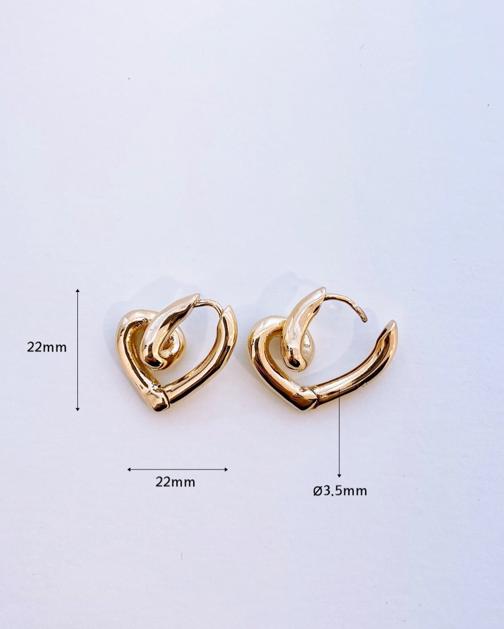 Gold heart knot earrings with size measurements 22mm x 22mm, 3.5mm thickness reference
