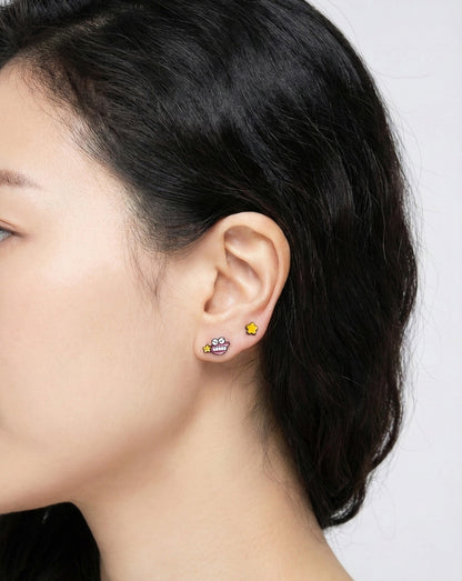 Chocobi character earring and yellow star stud worn together in curated ear piercing, layered earscape styling
