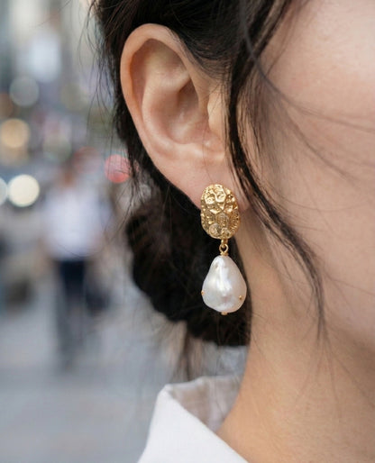 Silver baroque pearl drop earrings with hammered metal top on acrylic display