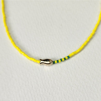 Lemon yellow seed bead choker featuring gold fish pendant and green accent beads detail shot