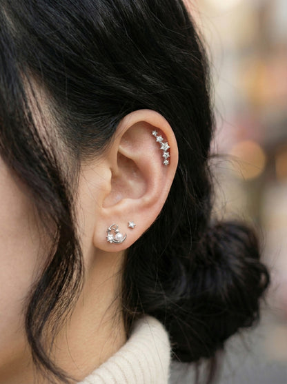 Ear styling featuring silver moon rabbit conch piercing layered with small star and CZ stud earrings