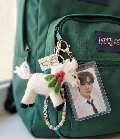 White felt horse bag charm on green JanSport backpack with colorful beaded name tag and photocard