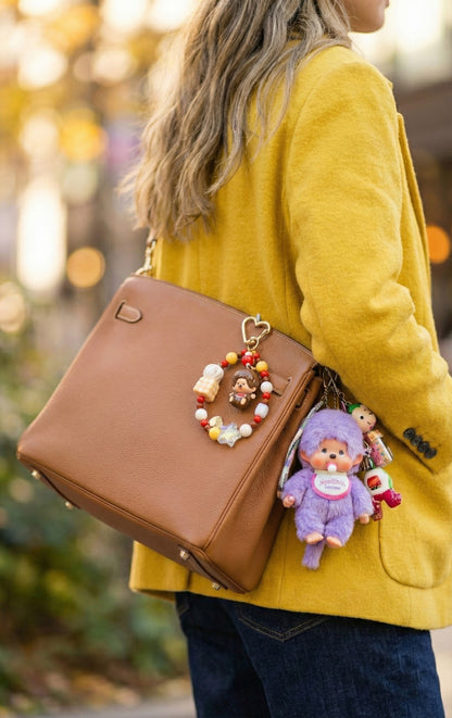 Woman wearing yellow cardigan with brown bag decorated with Monchhichi beaded keychain bag charm, autumn outdoor setting