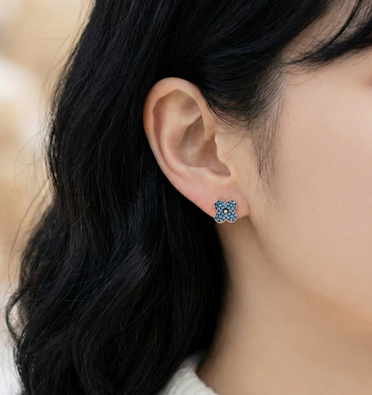 Profile view of woman wearing aqua blue clover stud earrings showing snug fit on earlobe