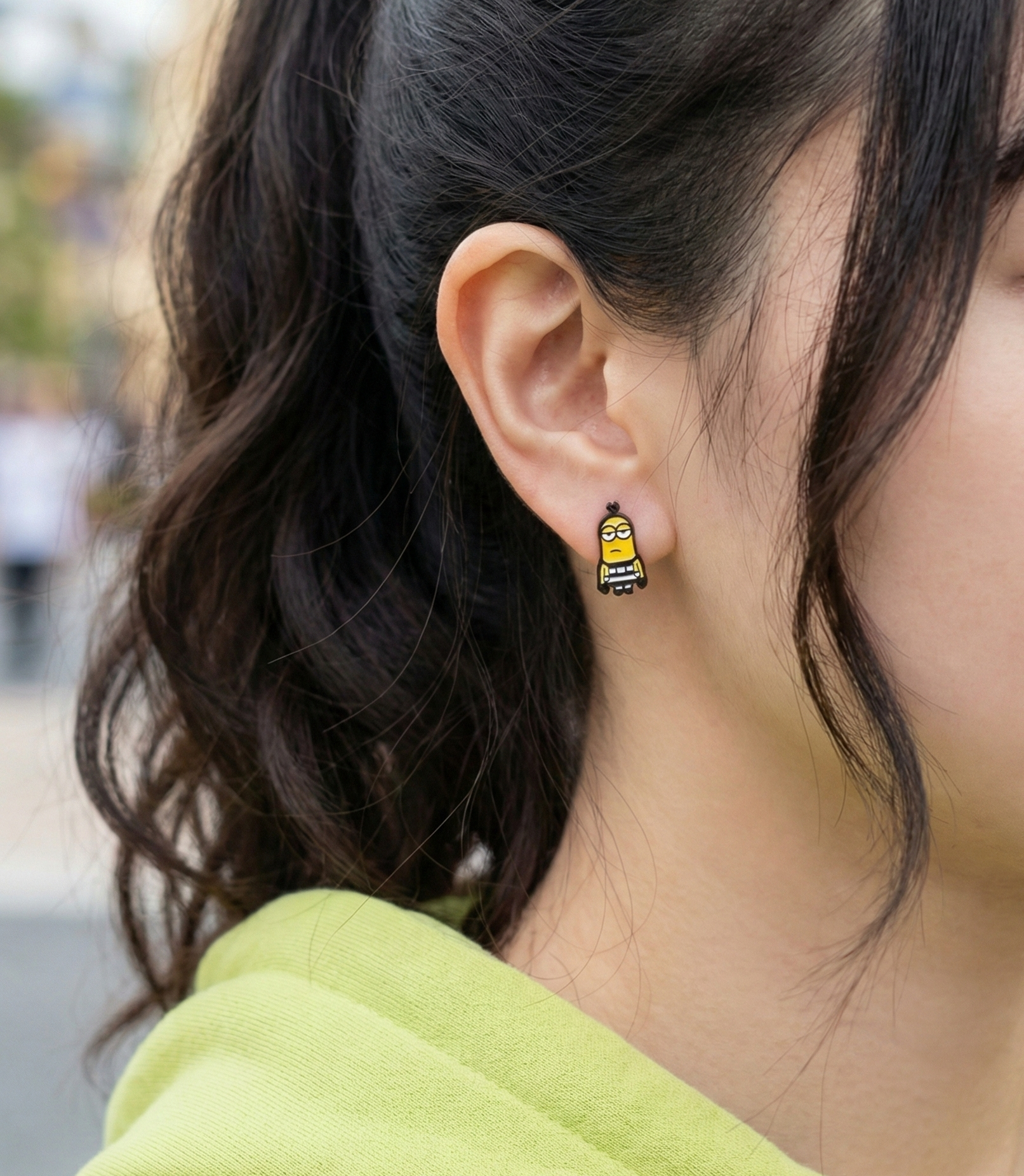 Side view of Minions prisoner stripe stud earring worn on ear, black and white striped character design