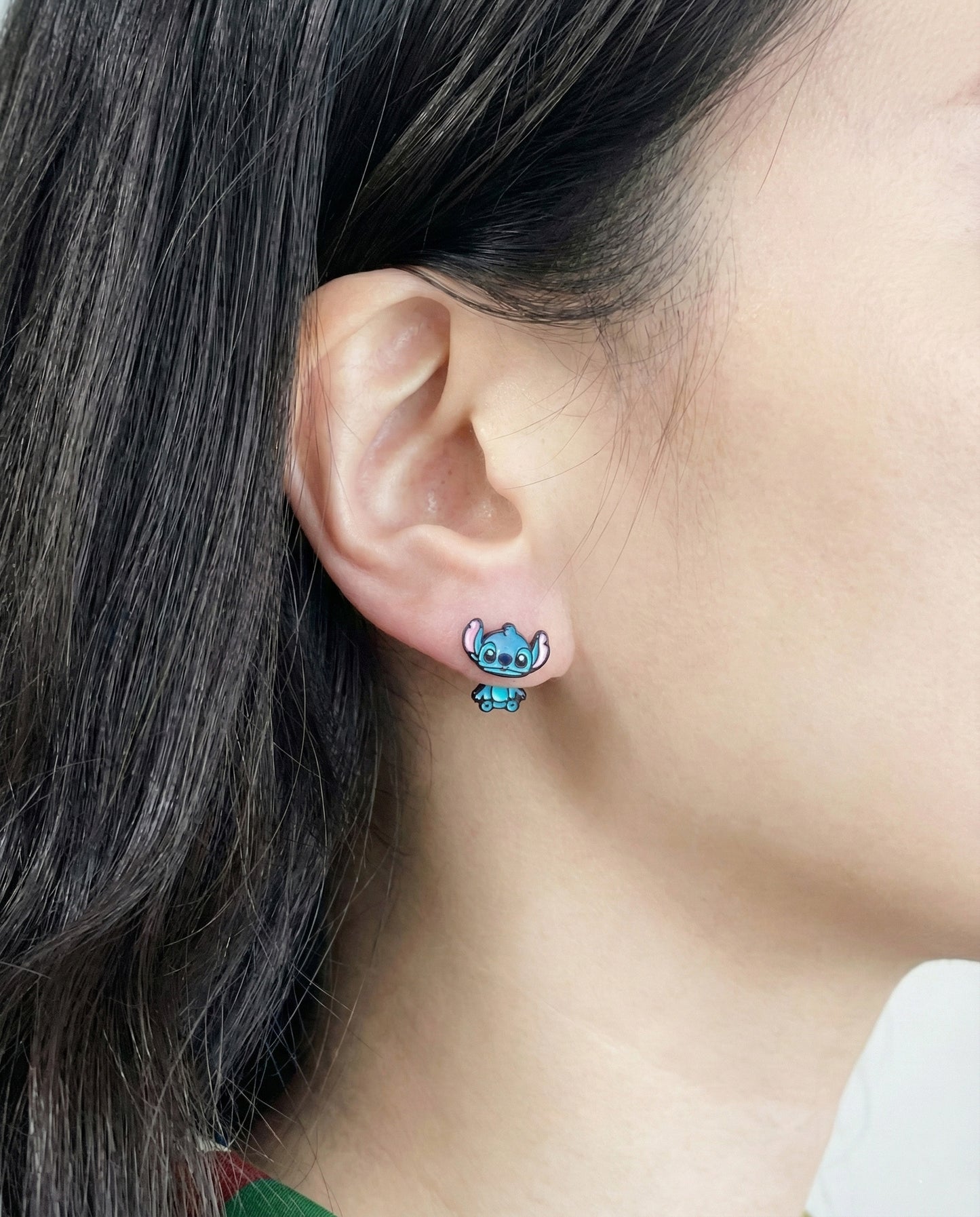 Close-up of Stitch-inspired 3D front back ear jacket earrings worn on ear showing dimensional character