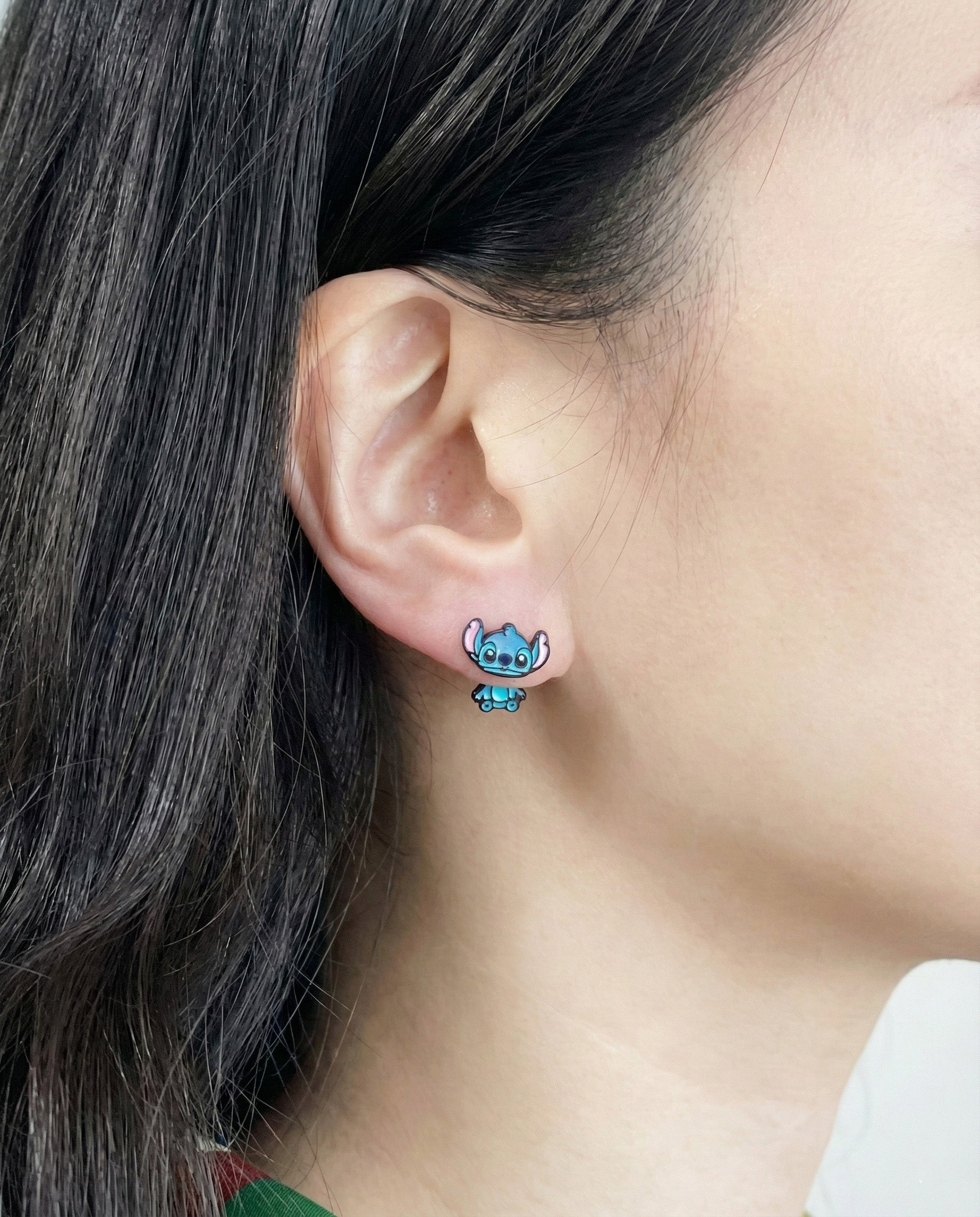 Close-up of Stitch-inspired 3D front back ear jacket earrings worn on ear showing dimensional character