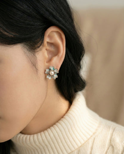 Korean woman wearing jade mint vintage flower earrings with white turtleneck sweater, side profile view