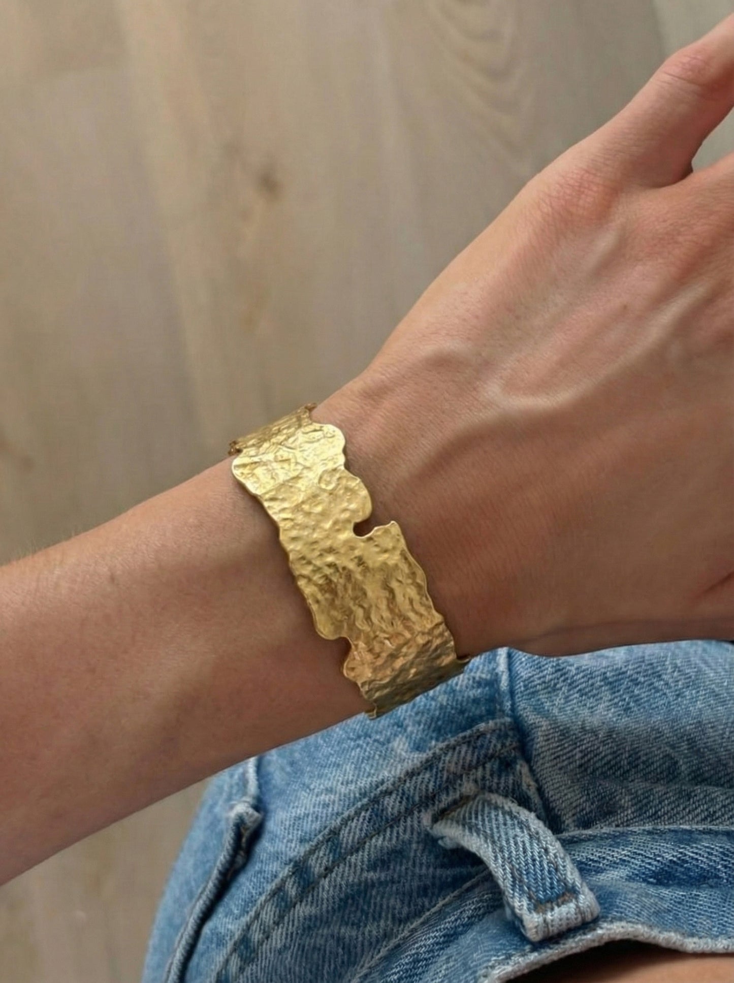 Gold hammered cuff on wrist with denim shirt - casual chic brass jewelry
