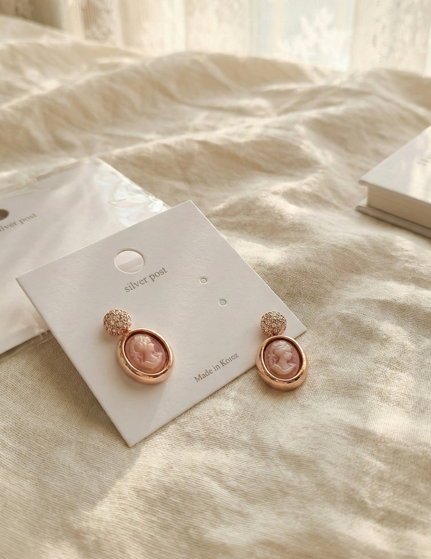 Romantic pink cameo earrings on white card with Made in Korea label