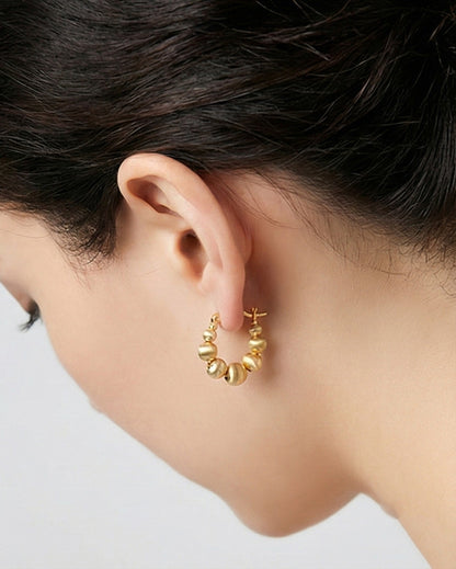 Woman wearing gold textured bead hoop earrings side profile view, showing elegant sphere design on ear, comfortable lightweight fit, gold-plated brass 925 silver posts, Korean handmade jewelry everyday style