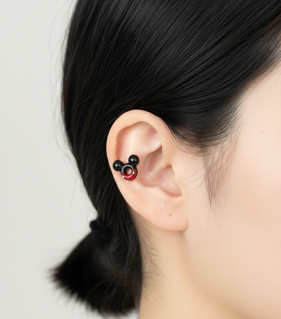 Close-up of a woman wearing a Mickey Mouse shaped stud earring on her upper lobe.